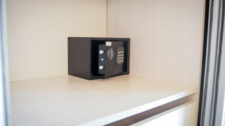 Closeup image of small open safe box in hotel room