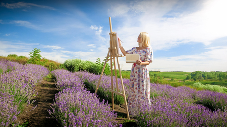 Happy smiling woman painting lavender field at morningの写真素材