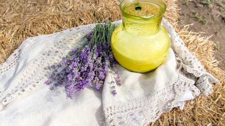Closeup image of fresh lavender flowers and milk jar on hayの写真素材