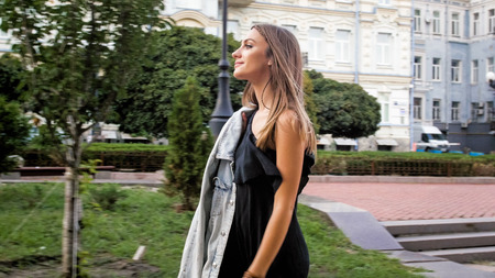 Portrait of beautiful elegant woman in dress walking in park