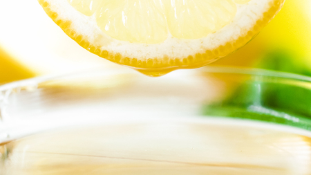 Closeup image of side of fresh lemon above cup of teaの写真素材