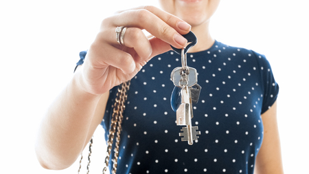 Closeup isolated image of young woman posing with keys from new houseの写真素材