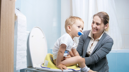 Portrait of smiling young mother with toddler boy in toiletの写真素材