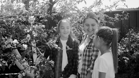 Black and white photo of family looking at trees in orchard