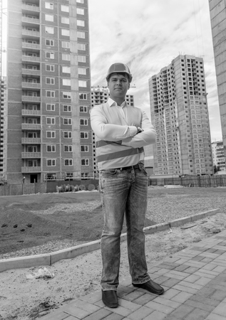 Black and white image of confident male architect standing on building siteの写真素材