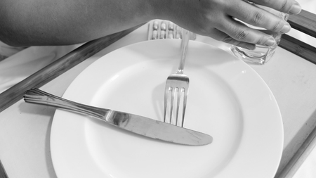 Closeup photo of female hand holding glass of water after having dinner in bedの写真素材
