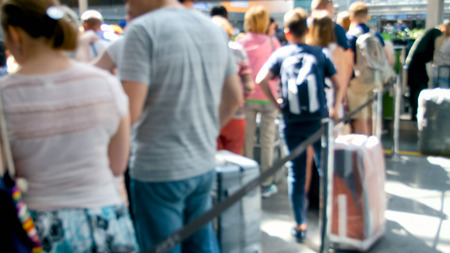 Blurred photo of people waiting for flight in airport terminal