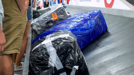 Closeup photo of bags and suitcases on luggage claim line at modern airport terminal
