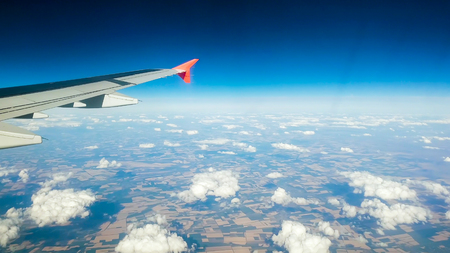 View from passenger seat on airplane wing and clouds against blue sky