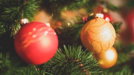 Closeup toned photo of needles and colorful baubles on Christmas tree. Perfect background for winter...