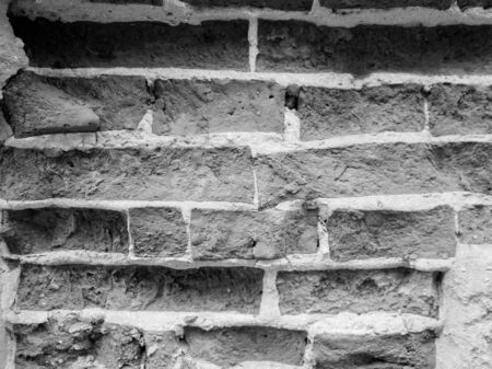 Black and white image of old damaged and cracked brick wallの写真素材