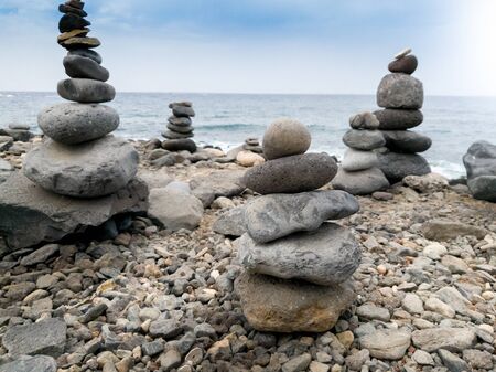 Beutiful photo of towers made of balancing rocks on the ocean beach. Concept of harmony and balance