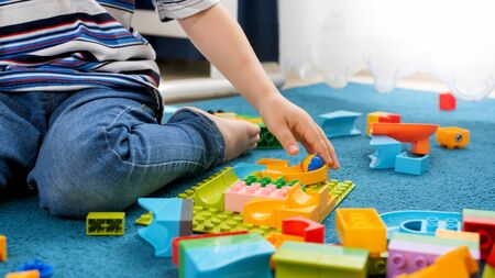 Closeup image of little toddler boy assembling track for marble run gameの写真素材