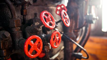Closeup photo of steam engine with pipes, valves and manometers at retro train