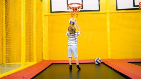Cute little boy playing in basketball on playground at amusement park.の写真素材