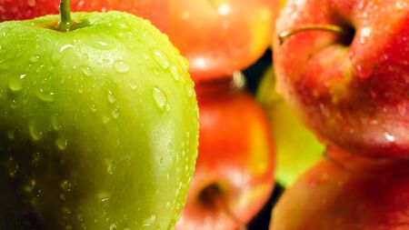 Closeup image of water droplets on green ripe apple lying on mirror surface. Abstract background of seasonal fruitsの写真素材