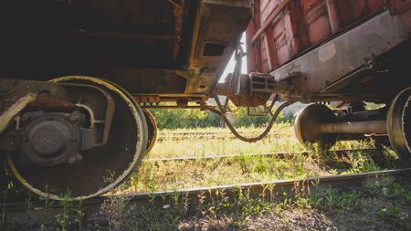 Two old rusty train cars connected with rusty coupler on railwayの写真素材