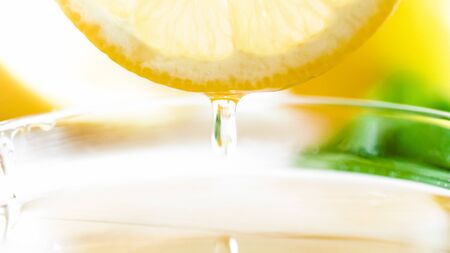 Macro image of honey droplet falling from cut lemon sliceの写真素材