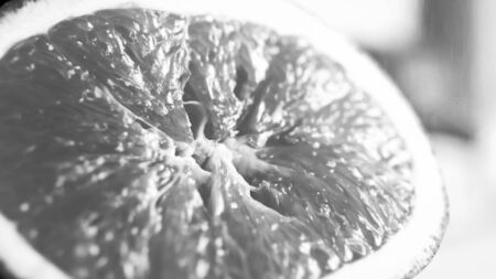 Black and white macro image of fresh cut orange halfの写真素材