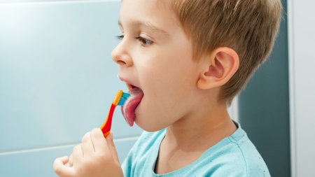 Portrait of little boy brushing teeth and cleaning tongue with toothbrush. CHild taking care of teeth and cleaning themの写真素材