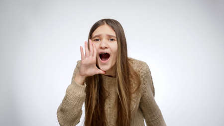 Happy cheering girl shouting and celebrating victory or success over white studio background