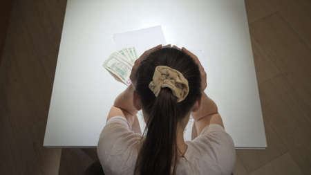 Stressed woman getting loan debt notification and getting upset. Concept of financial difficulties, poverty, bankruptcy, taxes and rent payment.の写真素材