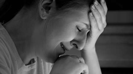 Black and white portrait of stressed crying woman lonely at nightの写真素材