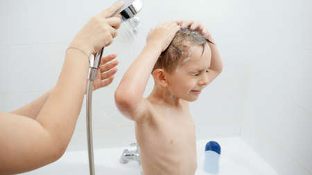 Young mother helping her little son washing under shower in bathroom. Concept of hygine, children...