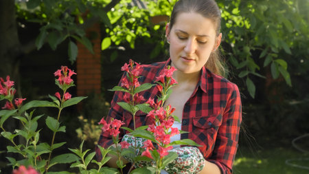 Portrait of young female gardener working at backyard flower gardenの写真素材