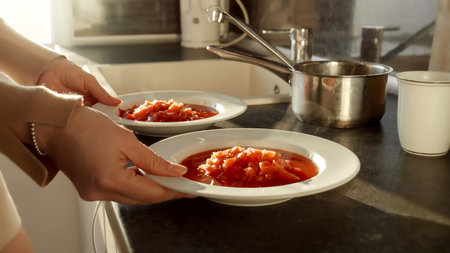 Closeup of woman serving dinner and taking two bowls with hot soup. Domestic food, cooking at home, housewife workingの写真素材