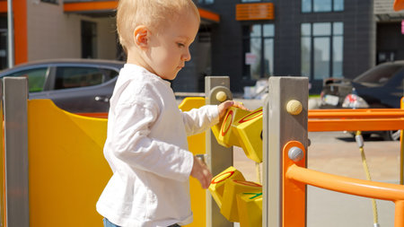Little baby boy playing with colorful abacus and bricks on the playground. Children developments,...