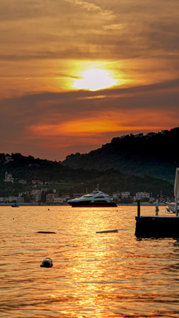 Vertical image of yacht going out of the sea port on sunset.の写真素材