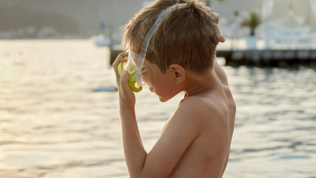 Little boy putting on snorkeling mask before swimming in sea. Holiday, summer vacation and tourism.の写真素材