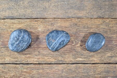 Three colorful stones on a wooden table.の写真素材