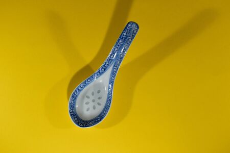 Ceramic spoon on a yellow background.の写真素材