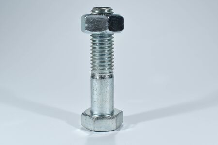Metal screw with nut on a white background.の写真素材