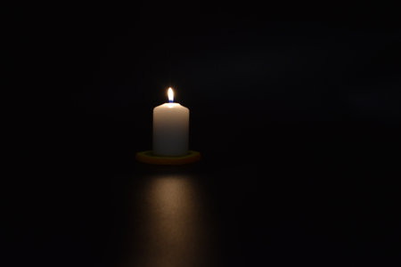 Burning candle on a black background. A burning candle on a black background.の写真素材