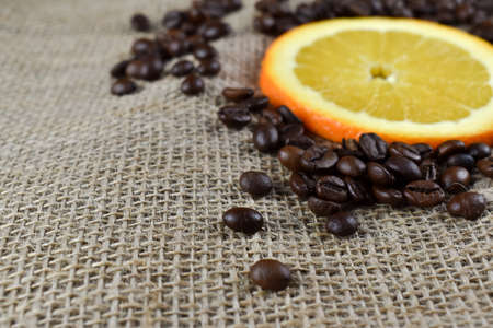 Coffee beans and orange on sackcloth background. Selective focus.の写真素材