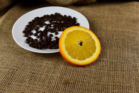 Coffee beans and orange on sackcloth background. Selective focus.の写真素材