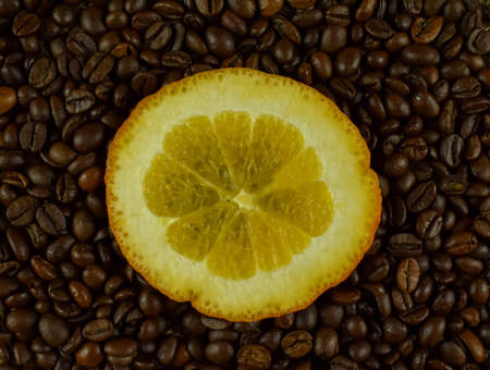 Coffee beans and slice of orange on a black background.の写真素材
