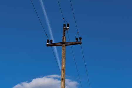 Electricity post with blue sky and white clouds in the background.の写真素材