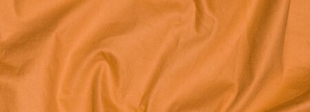 crinkled orange textile material with visible textureの写真素材