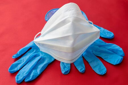 medical mask and gloves on a red background.の写真素材