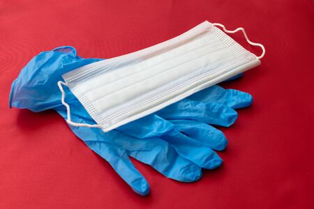 medical mask and gloves on a red background.の写真素材