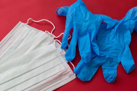 medical mask and gloves on a red background.の写真素材