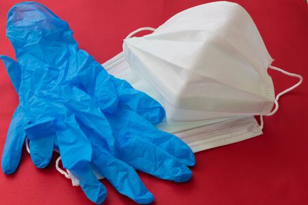medical mask and gloves on a red background.の写真素材