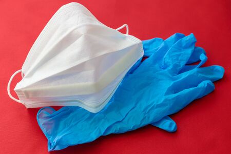 medical mask and gloves on a red background.の写真素材