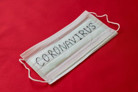 Medical mask with the inscription Coronavirus on a red backgroundの写真素材