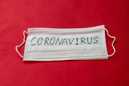 Medical mask with the inscription Coronavirus on a red backgroundの写真素材