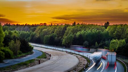 car lights at sunset on the background of the forestの写真素材